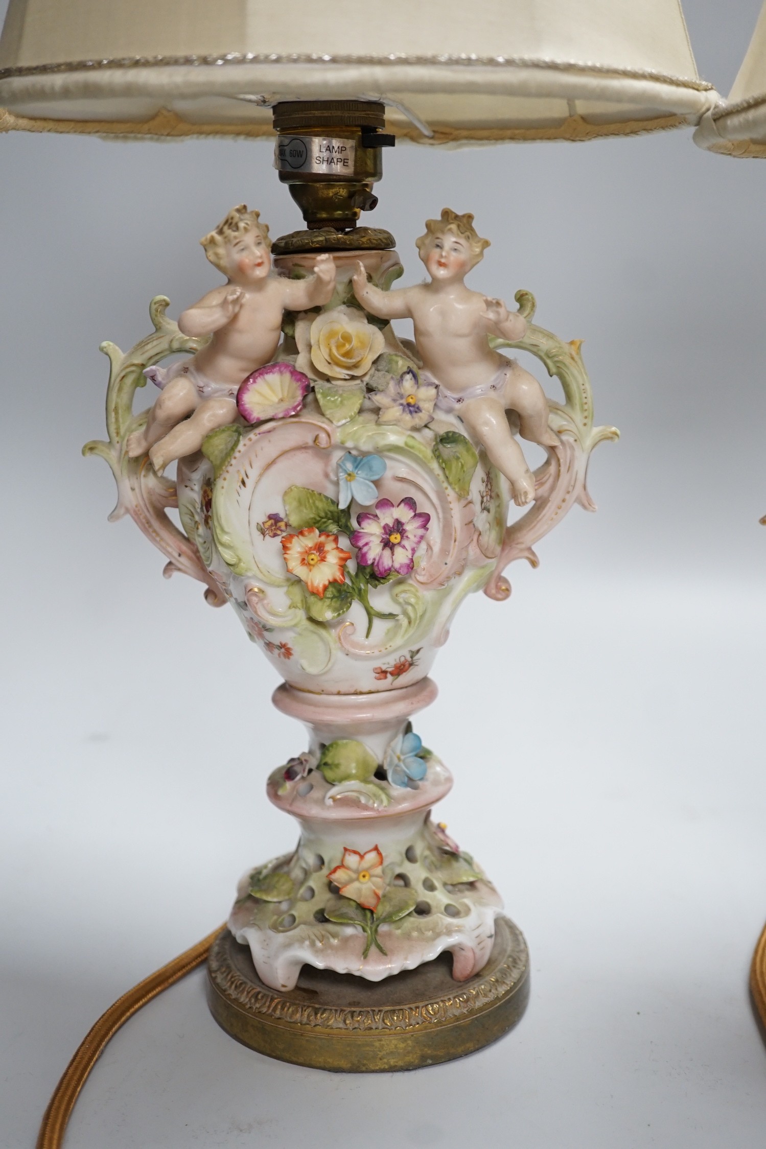 A pair of German porcelain flower encrusted lamps, height 24cm